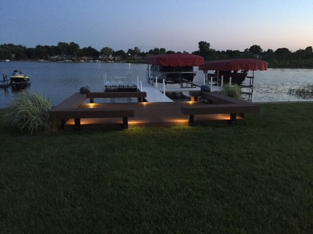 Custom lakeside deck with floating benches and deck lighting