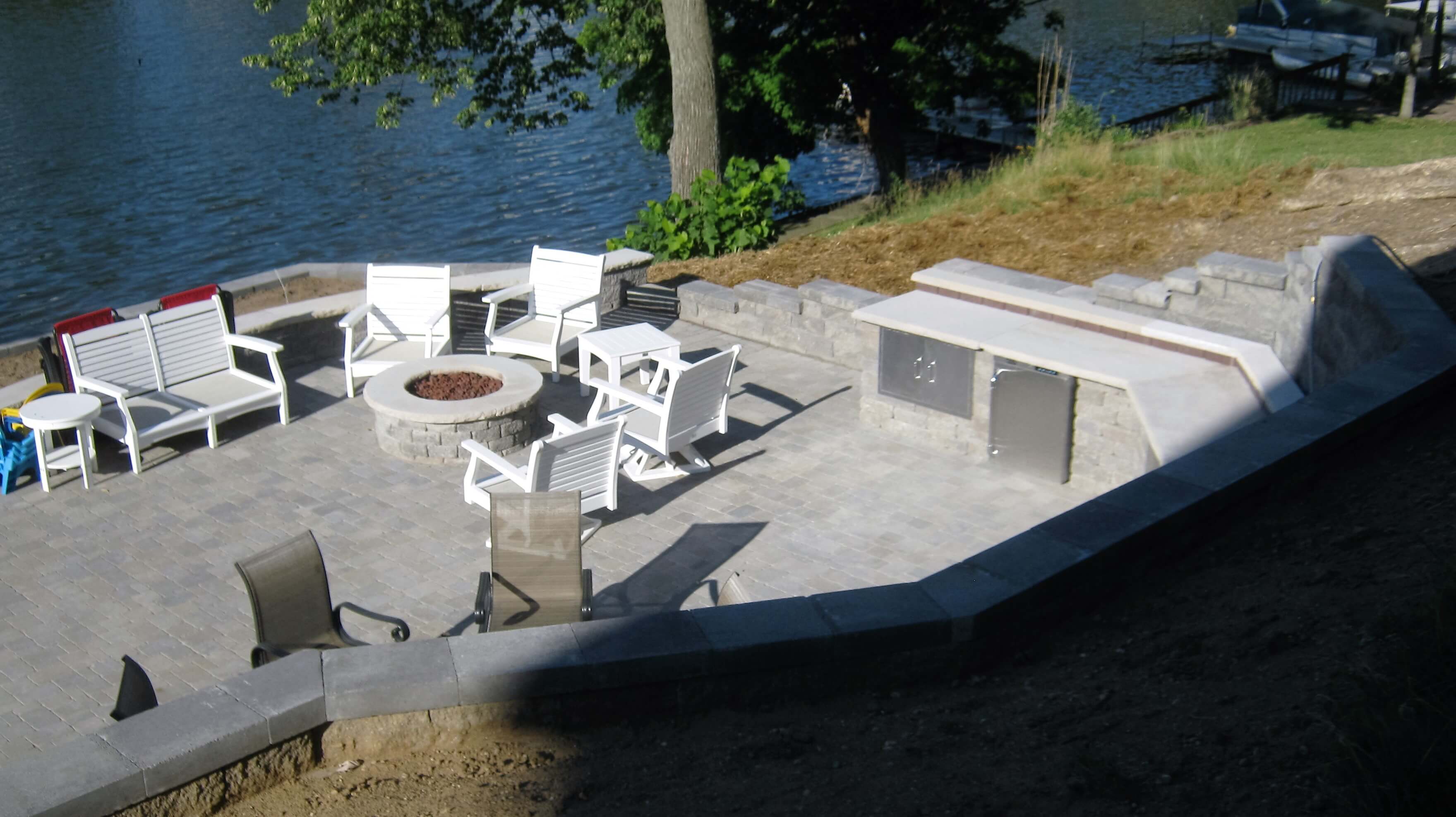 Custom lakeside patio with fire pit and outdoor kitchen