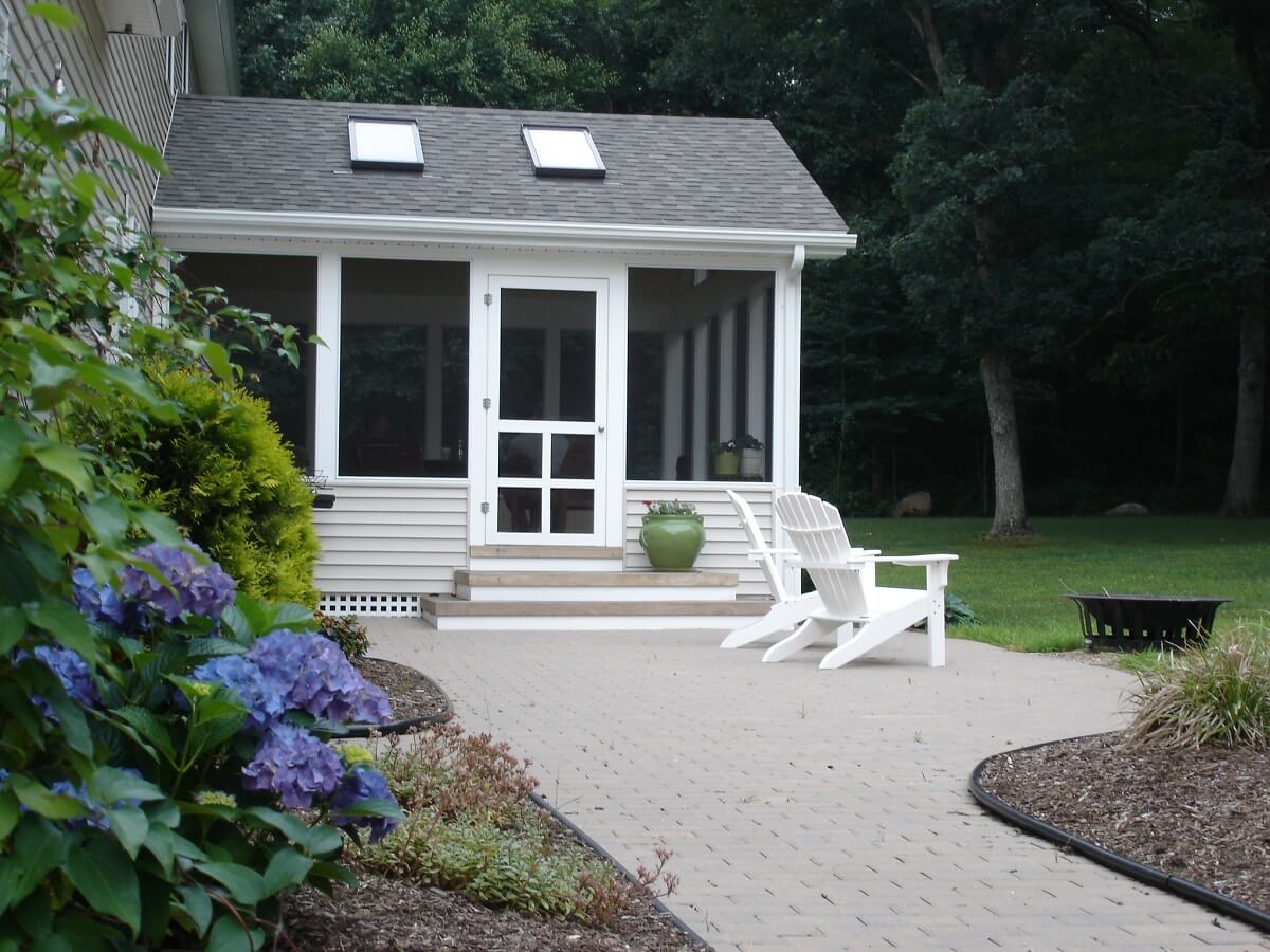 Exterior view of screened porch with outdoor lounge chairs