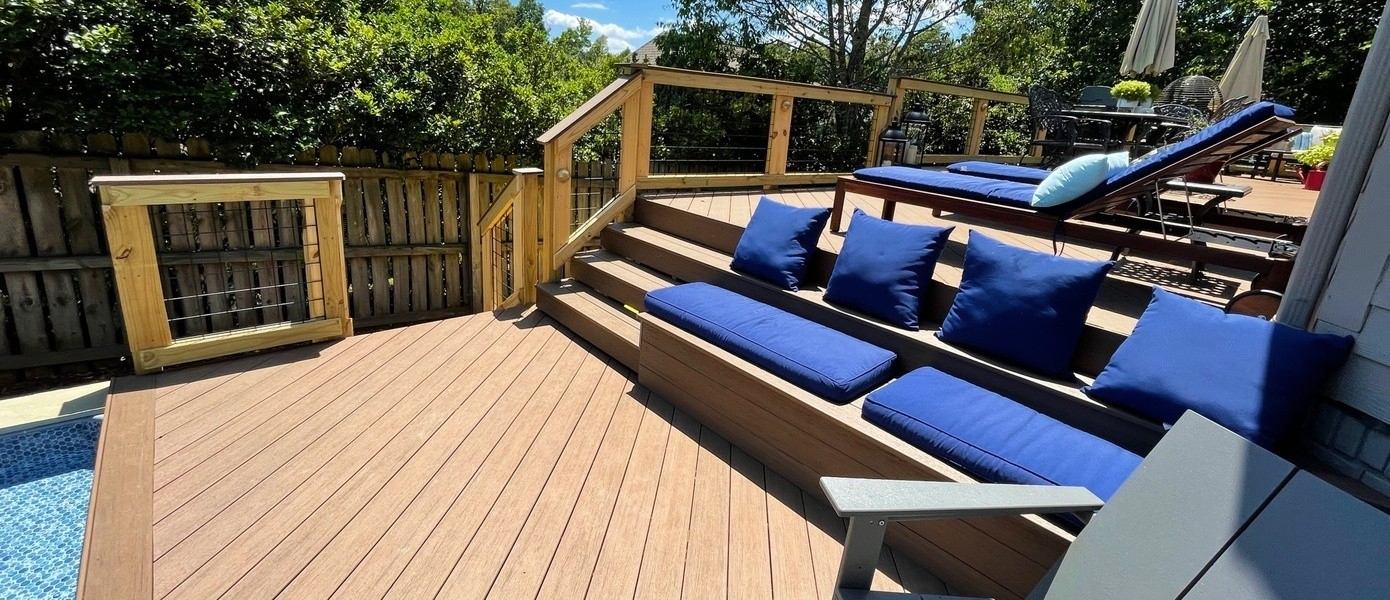 Wood deck with lounge seating overlooking pool.