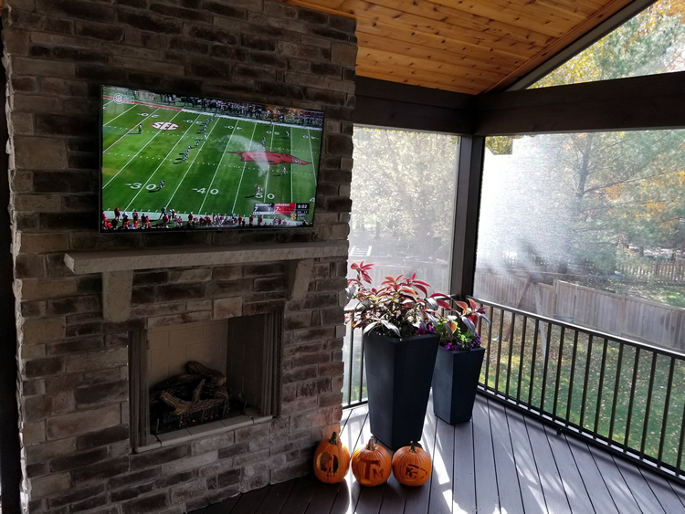 Screened porch with stone fireplace and TV