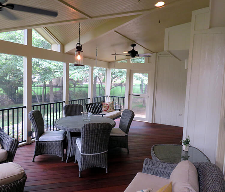 screened porch with chairs and table