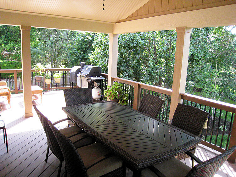 Dining area and outdoor kitchen on covered porch and deck