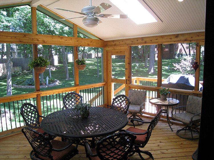 Dining area on screened porch with backyard view