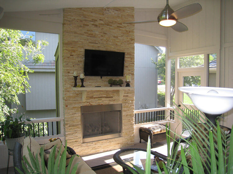Custom outdoor fireplace and flat TV on custom screened porch