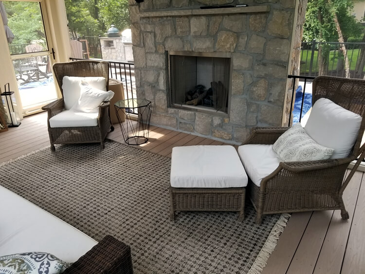 Custom outdoor fireplace and lounge area on screened porch