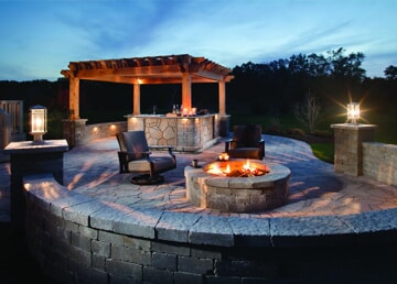outdoor stone patio with fire feature and outdoor kitchen