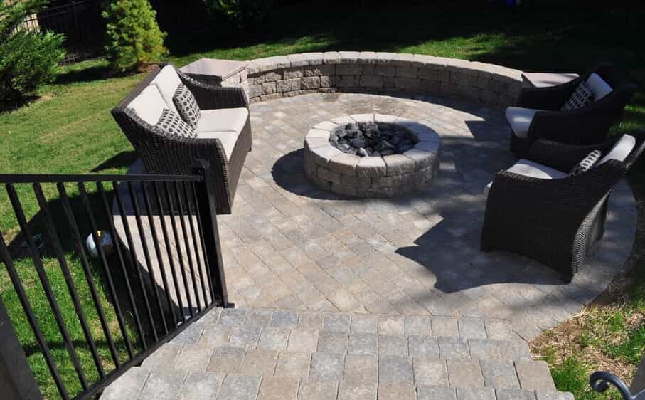 stairs leading to patio with seating wall and built in firepit