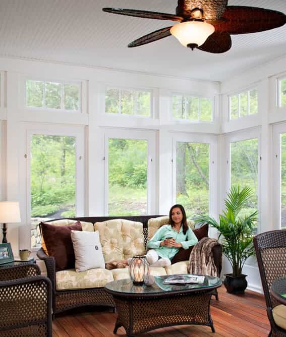 woman sitting on her couch in a sunroom