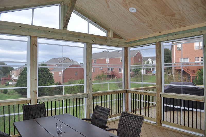 Screened porch with table and chairs.