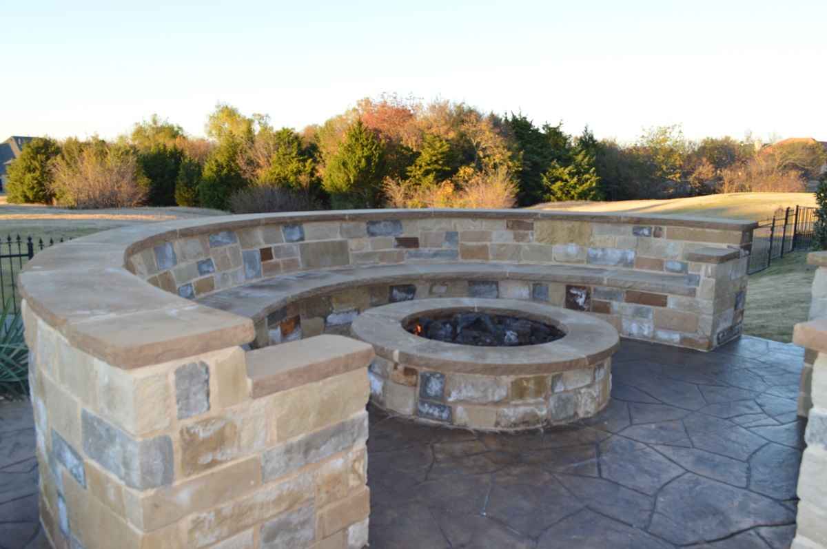 Stone seating with fire pit in backyard