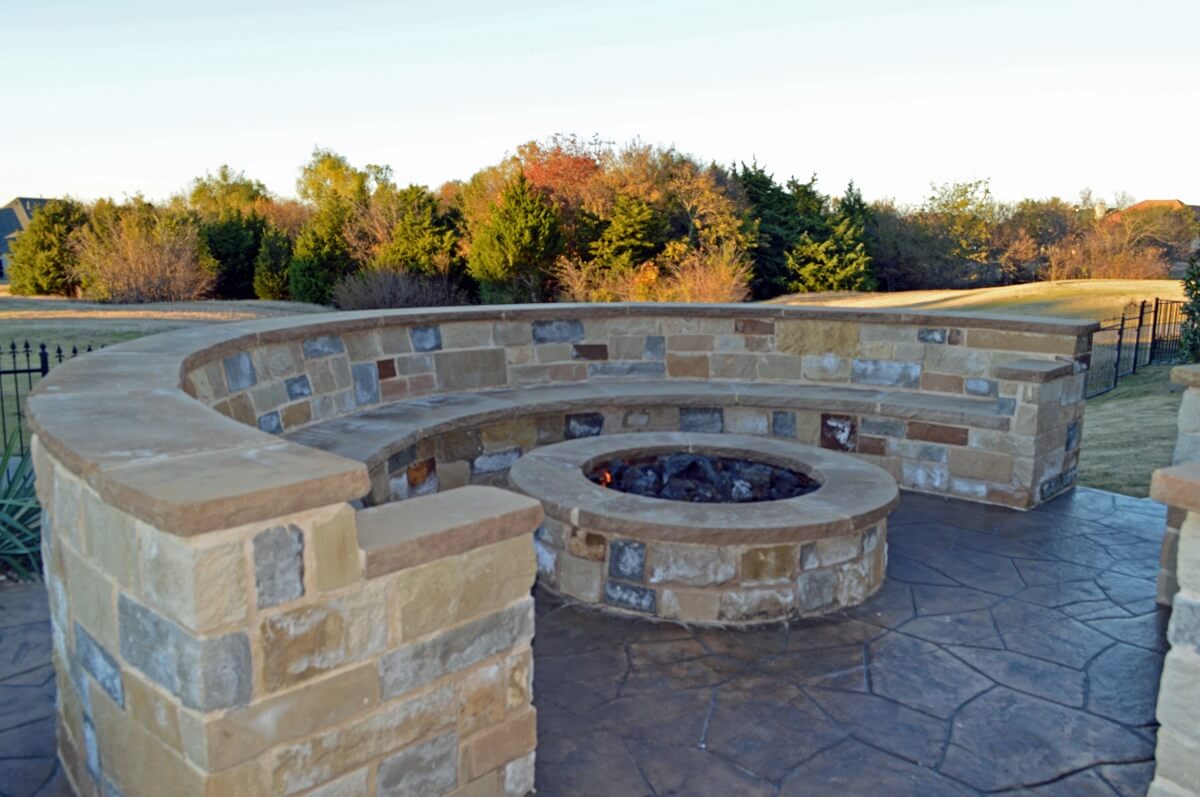 Custom stone fire pit with seating wall