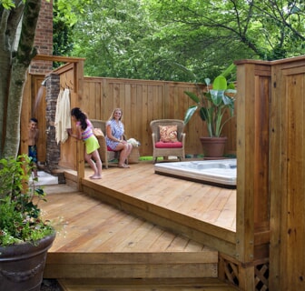 family enjoying deck with in ground hot tub and outdoor shower