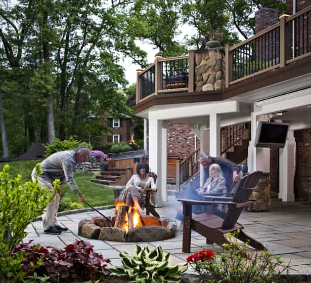 Group of people gathered on a deck with a firepit