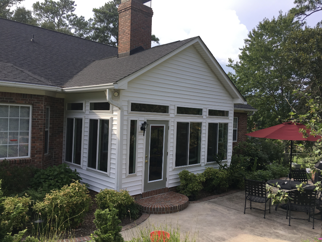 The white exterior of a sunroom seen next to a home's garden in Columbia, South Carolina