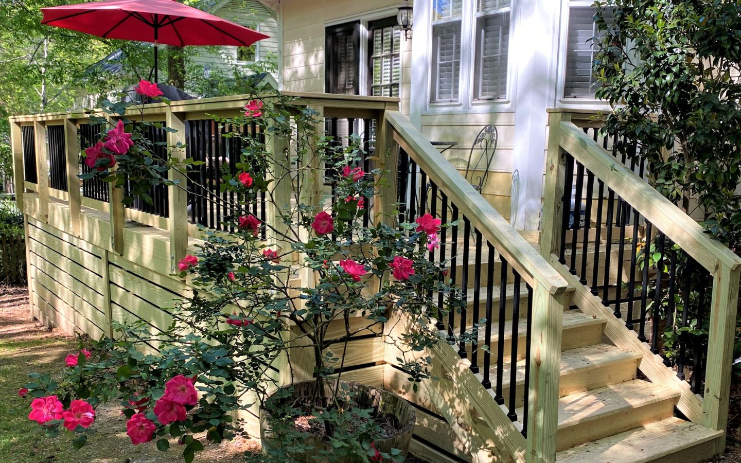A deck with stairs and a red umbrella
AI-generated content may be incorrect.