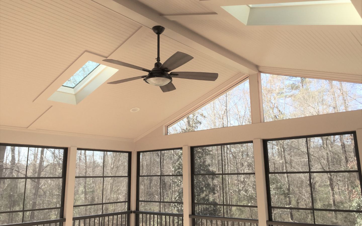 A ceiling fan in a room with windows
AI-generated content may be incorrect.