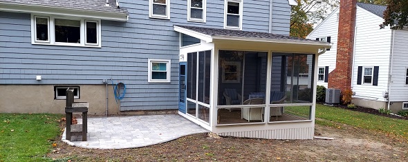 backyard of a blue house with a small deck