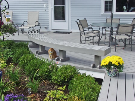 outdoor deck with large bench and cat