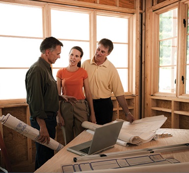 Three adults reviewing blueprints