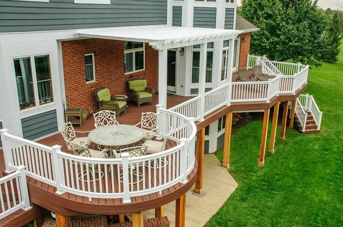 Second story wooden deck with white railing and outdoor furniture