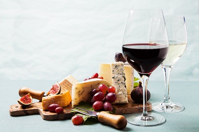 wine glasses next to cheese board