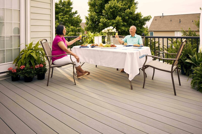 couple cheers at table on backyard deck