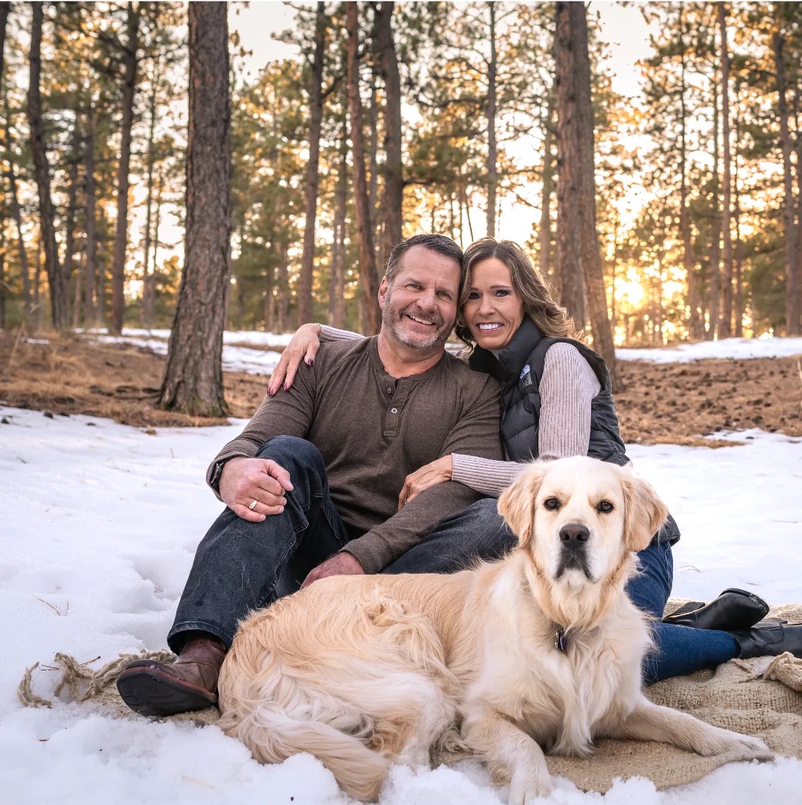 The Colorado Springs Team posting in snow with their golden retreiver