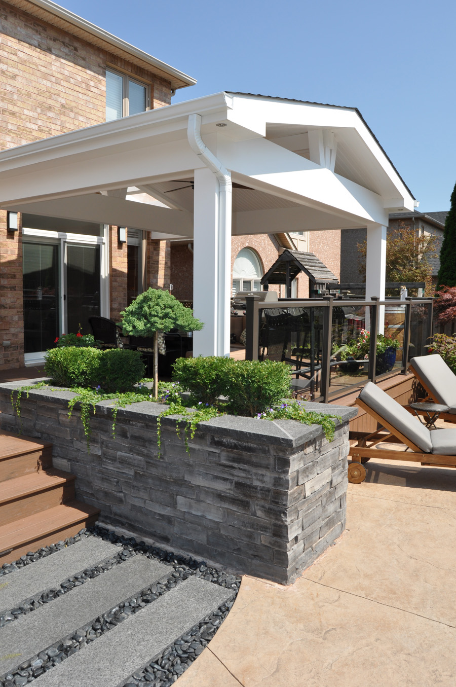 Composite covered porch with stacked stone planter box.