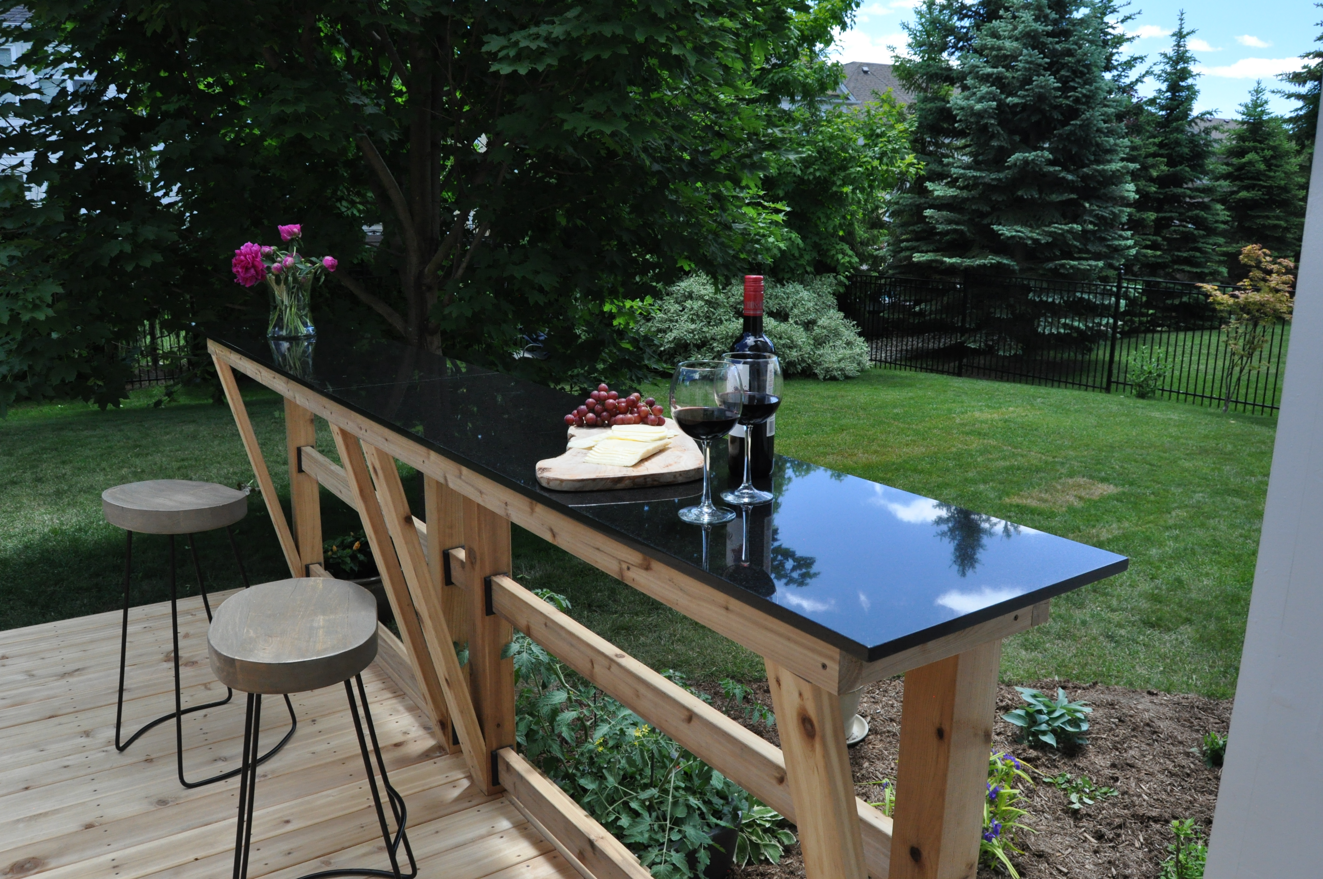 Granite top bar on a deck with wine and cheese.