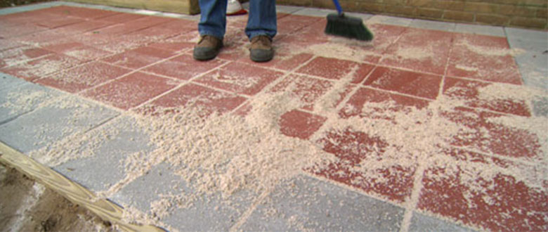 polymeric sand being swept into pavers