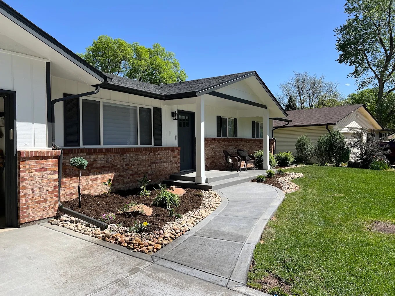 White home with black trim that has a covered porch